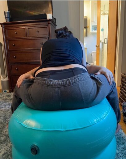 vrouw vangt weeën op op CUB baarkruk tijdens bevalling