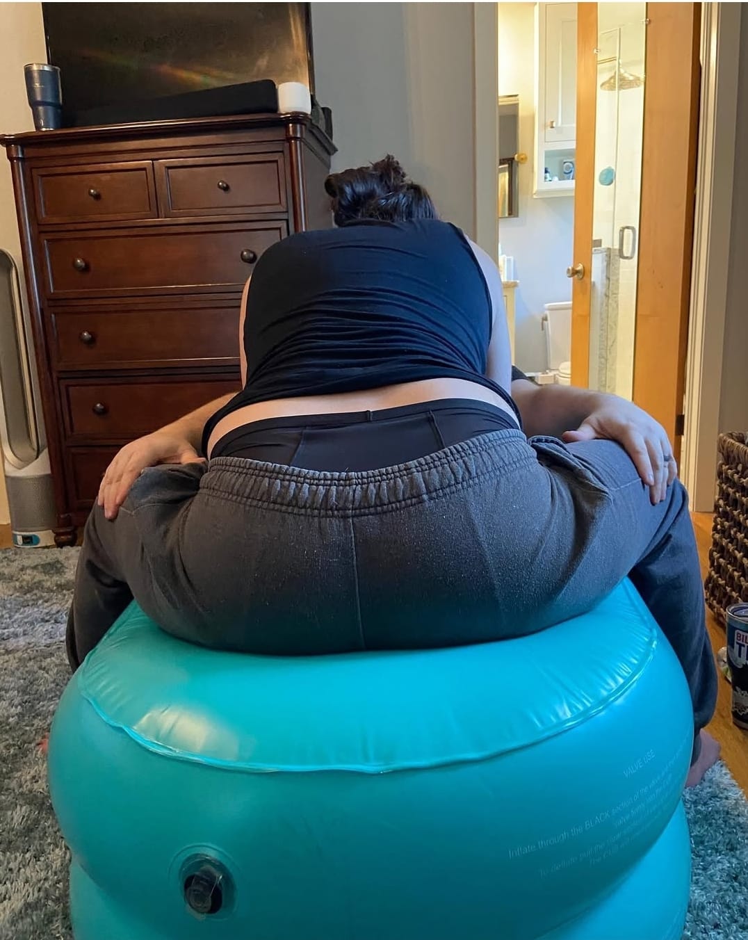 vrouw vangt weeën op op CUB baarkruk tijdens bevalling